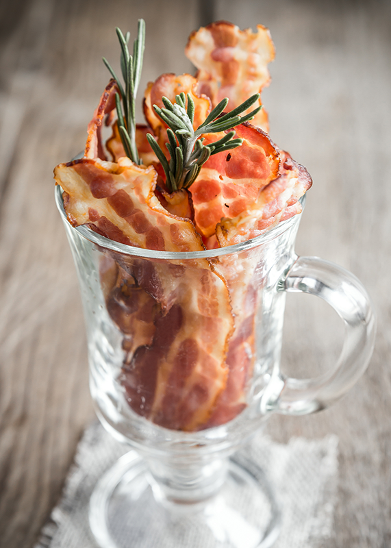 fried bacon in glass with rosemary