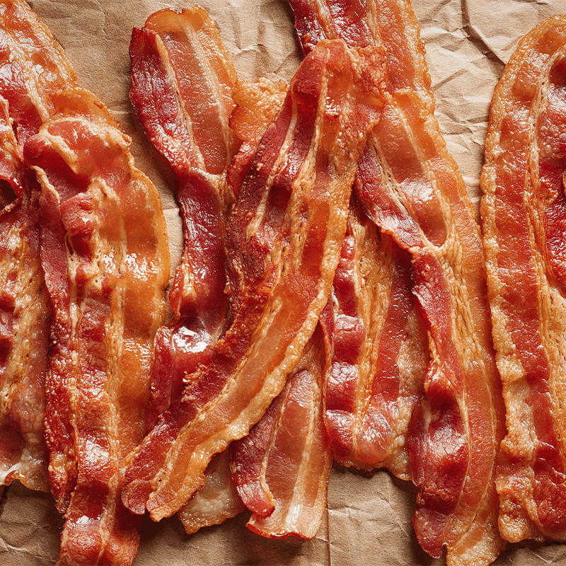 spread of cooked bacon on parchment or kraft paper